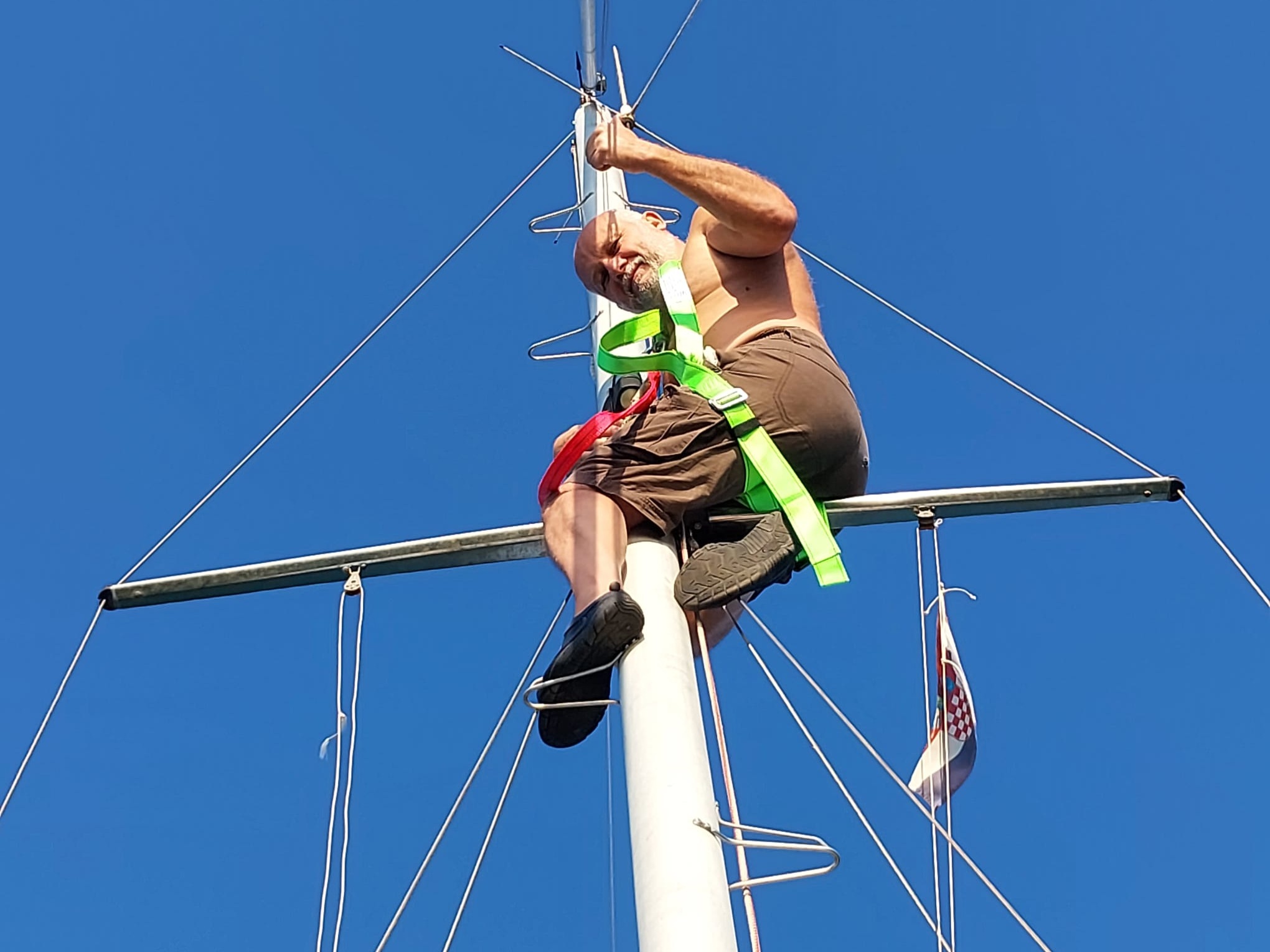 Franz up at the top of STRIGA's mast, doing his own rigging maintenance